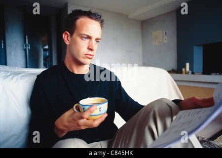 Man working with coffee in bedroom Stock Photo