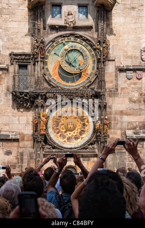 Tourists taking photos of old astronomical clock in the center square of Prague. Stock Photo