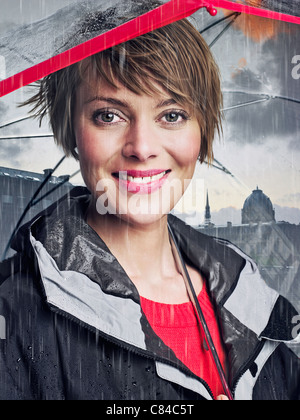 Smiling woman under umbrella in rain