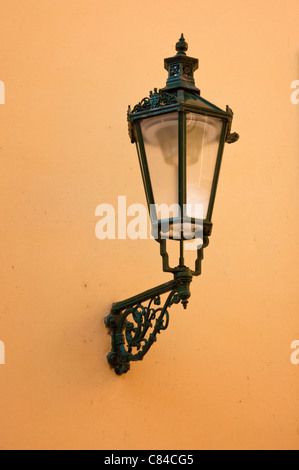 Wrought-iron lantern with its shadow on the yellow wall, Prague, Czech Republic Stock Photo