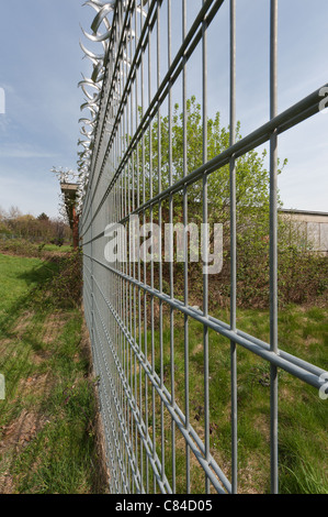 Keep out security fence protecting from burglary against an early morning sky Stock Photo