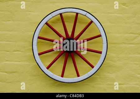 a colorful wheel on a yellow wall as modern art uk Stock Photo