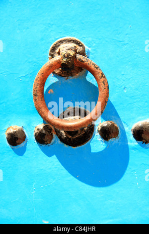 Metal door knocker handle on blue wooden Moroccan door, in the medina/old town at  Essaouira, Morocco, north Africa Stock Photo