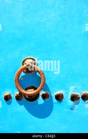 Metal door knocker handle on blue wooden Moroccan door in the medina/old walled town at Essaouira, Morocco, north Africa Stock Photo