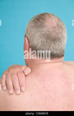 Man with hand over left shoulder Stock Photo