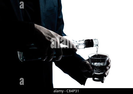 one caucasian man hands close up pouring white alcohol in a glass silhouette in studio isolated white background Stock Photo