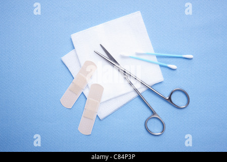 Blue cotton swabs, bandages, pieces of cotton, and scissors Stock Photo