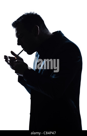 one caucasian man portrait smoking lighting cigarette silhouette in studio isolated white background Stock Photo