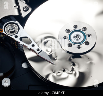 Magnetic disc inside a computer hd unit showing damage to the mirror surface of the magnetic discs and read write head Stock Photo