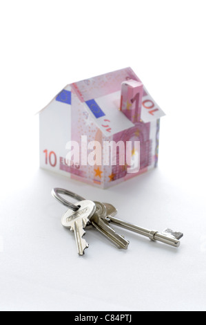 Bunch of keys and model house folded with Euro banknotes Stock Photo