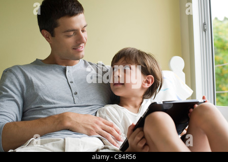 Father and son relaxing together with electronic book Stock Photo