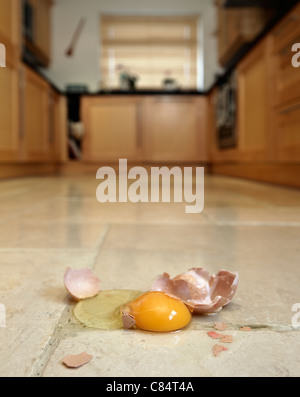 Smashed egg on kitchen floor. Stock Photo