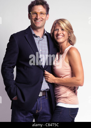 Smiling casually dressed happy young woman and a man isolated on gray background Stock Photo