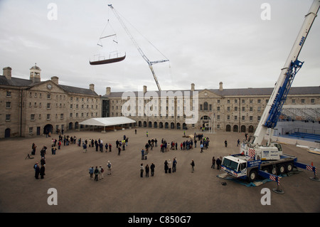 Onlookers watch as the replica viking ship 'Sea Stallion' is lifted over the National Museum buildings at Collins Barracks. Stock Photo