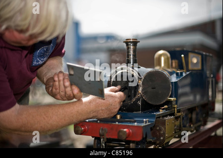 Miniature railway enthusiast tends to his steam engine at Canvey island, Miniature railway club, Essex, UK Stock Photo