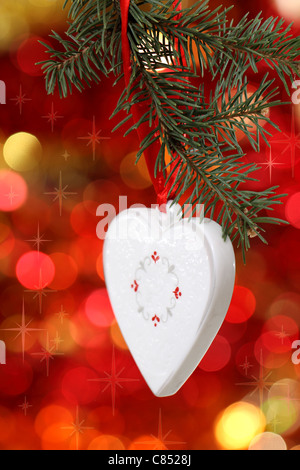 Christmas white heart with red ribbon against blurred background Stock Photo