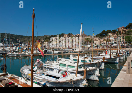 Port Soller harbour with small local  fishing boats waterside restaurants in background Palma de Mallorca Spain Stock Photo