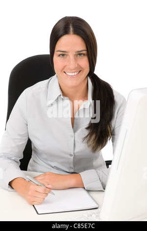 Successful business woman at office smiling sitting table write notepad Stock Photo