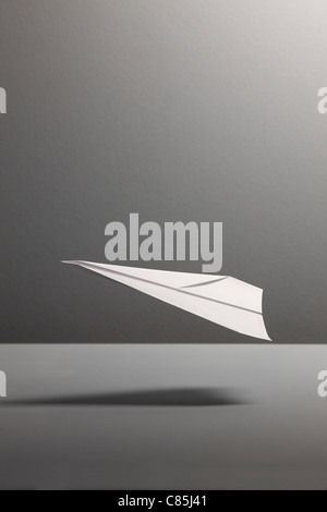 Paper aeroplane against gray background Stock Photo