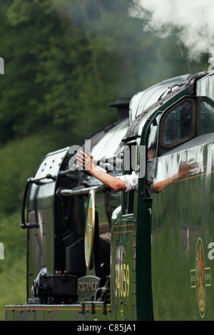 Driver waving goodbye as steam train leaves Horsted Keynes Stock Photo