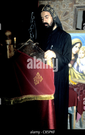 Coptic priest reads from the lectern in Deir al Muharraq monastery Egypt Stock Photo