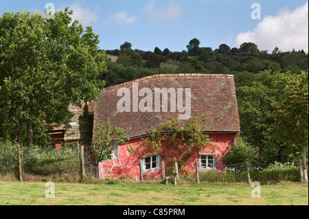 A little crooked house - a pretty and remote rural cottage in the countryside of Herefordshire, UK, painted with a pink limewash Stock Photo