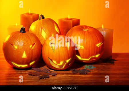 Halloween pumpkin with candles, warm autumn holiday background, traditional jack-o-lantern, night party decoration Stock Photo