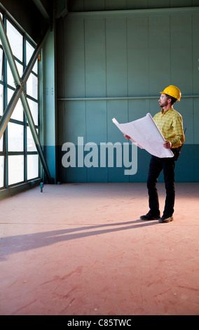 Caucasian architect reviewing blueprints Stock Photo