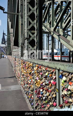 Love Padlocks, or Love Locks affixed to a security fence on Hohenzollern bridge in Cologne, Germany Stock Photo