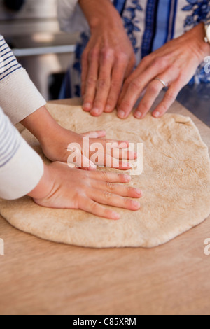 Helping mom knead dough Stock Photo