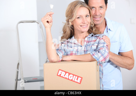 Couple stood by packing boxes Stock Photo