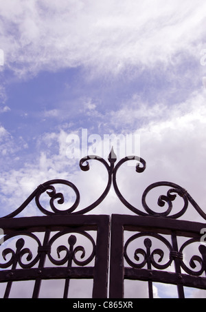 Sky view through old decorated metal gates. Architectural solution made ??of steel. Stock Photo