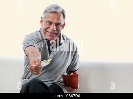 Portrait of an old man offering money Stock Photo