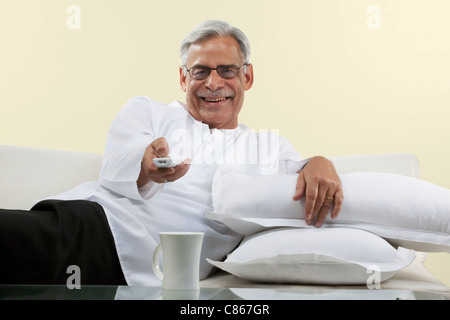 Old man watching tv Stock Photo