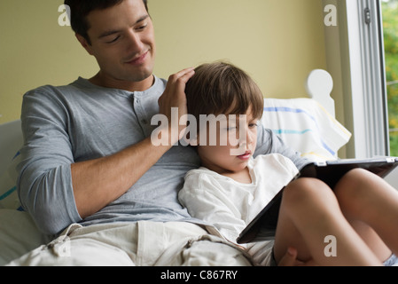 Father and son relaxing together with electronic book Stock Photo