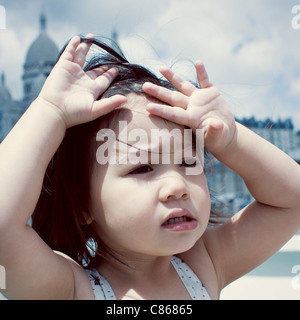 Little girl feeling hot under sun Stock Photo