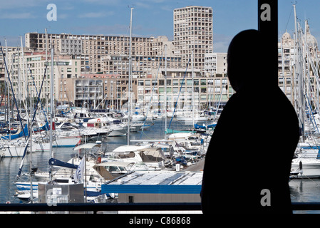 Silhouette of person looking at view of harbor Stock Photo