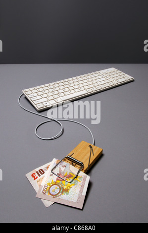 British pound banknote in mousetrap connected to keyboard Stock Photo