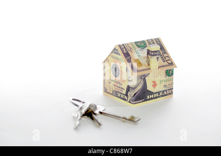 Model house folded with dollar bills and keys Stock Photo