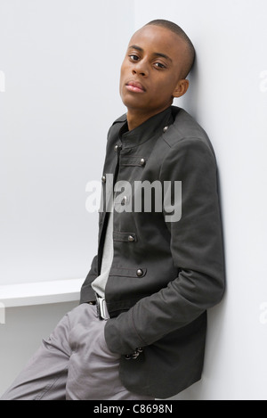Young man leaning against wall with hands in pockets, portrait Stock Photo