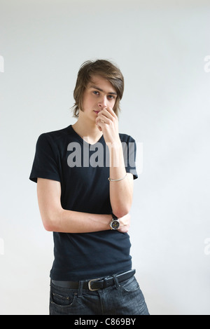 Young man looking pensively at camera, portrait Stock Photo
