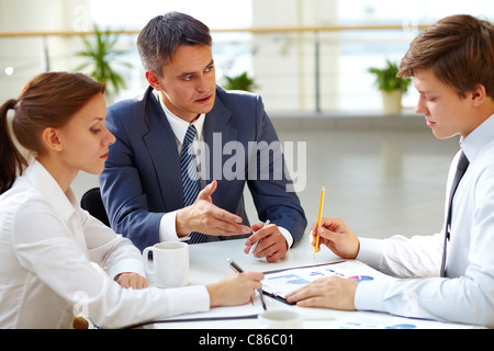 Young office worker reporting to his boss about work Stock Photo