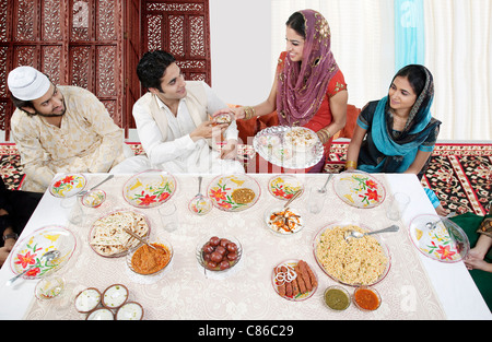 Muslim woman serving food during Id Stock Photo