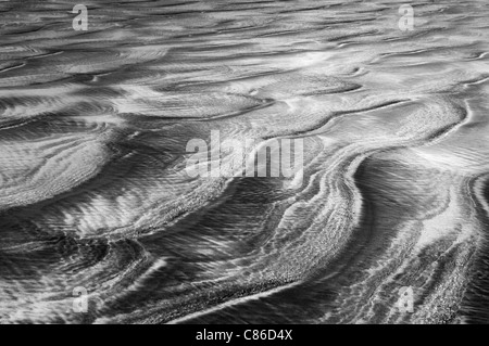 Patterns in the sand left by the retreating sea. Stock Photo