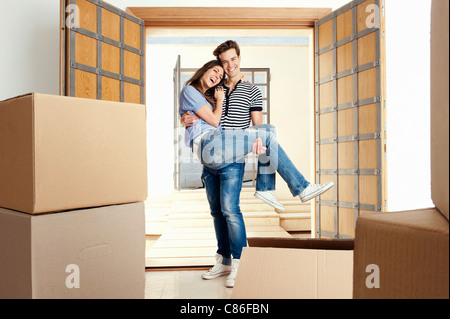 Man carrying girlfriend over threshold Stock Photo