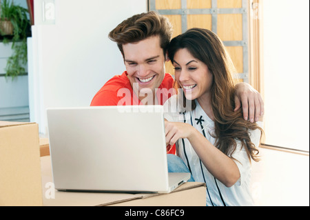 Smiling couple using laptop together Stock Photo