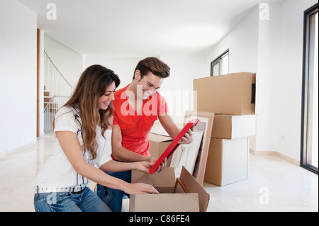 Couple unpacking box in new home Stock Photo