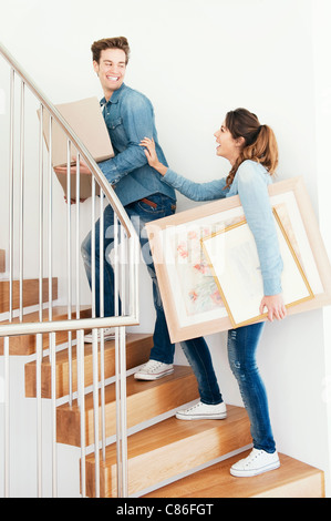 Couple carrying boxes upstairs in new home Stock Photo - Alamy