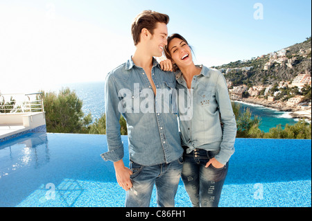 Smiling couple standing beside pool Stock Photo