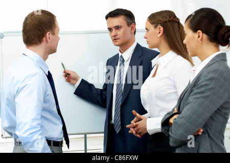 Confident boss explaining something to his colleagues Stock Photo